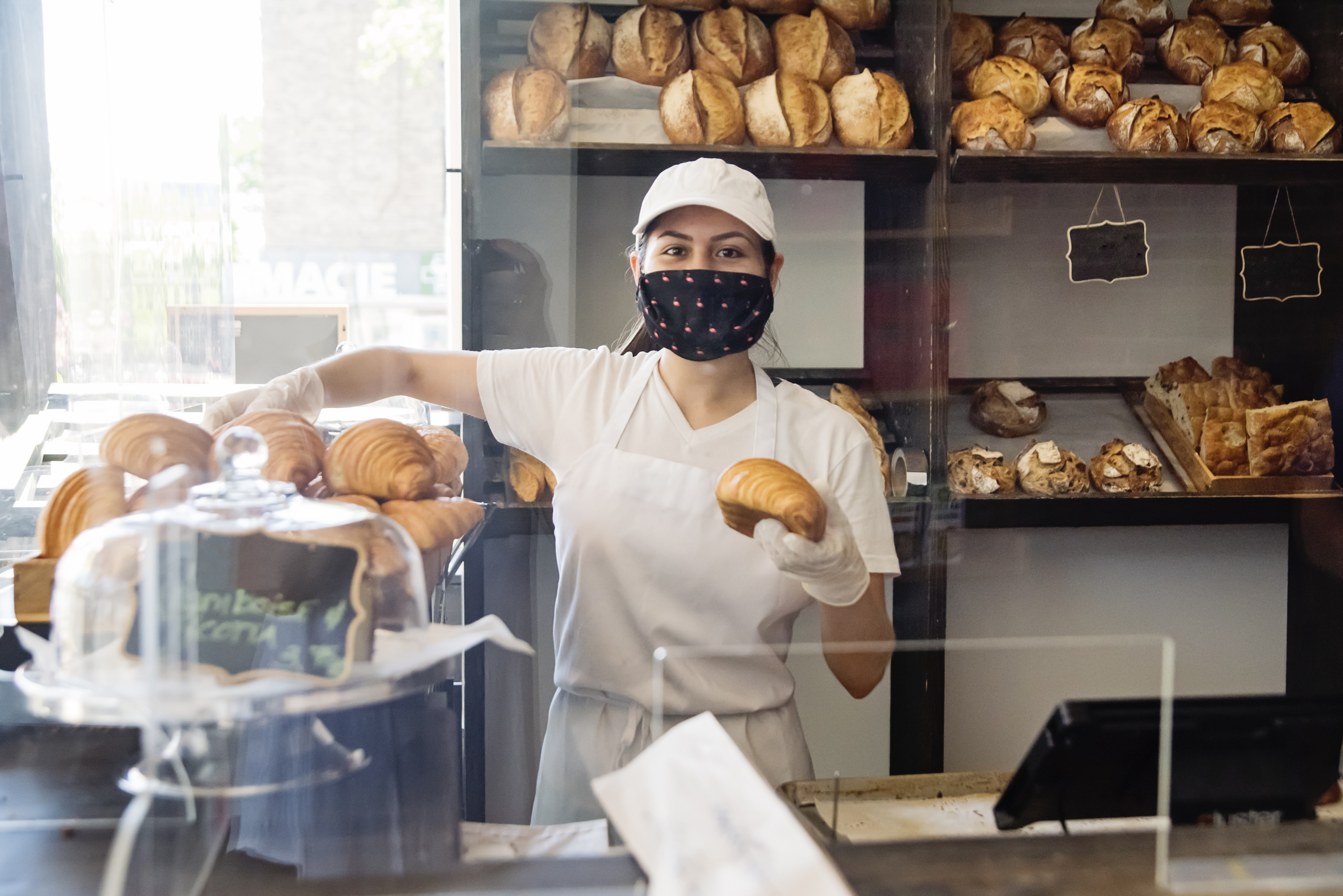 woman working in bakery with mask on
